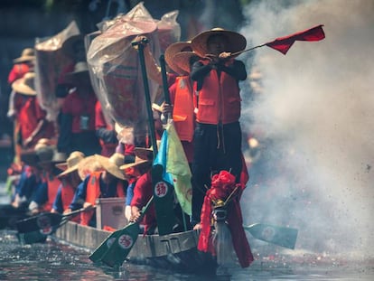 Un grupo de remeros realiza un espectáculos con pirotecnia durante una carrera de barcos de dragón, en Guangzhou, China.