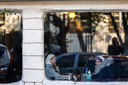 Dos mujeres sonrien en el interiro de un restaurante.