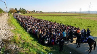 Policiais diante dos imigrantes que acabavam de cruzar a fronteira entre a Croácia e a Eslovênia, em outubro de 2015