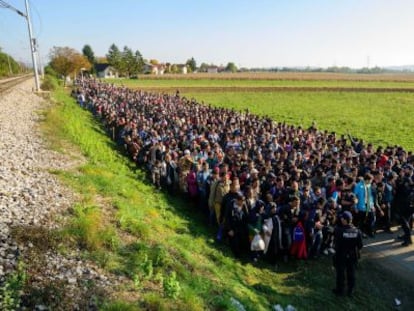 Polic&iacute;as frente a los emigrantes que acababan de cruzar la frontera entre Croacia y Eslovenia, en octubre de 2015. 
