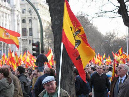 Un anciano acompaña la manifestación del PP contra la política antiterrorista del Gobierno sujetando una bandera del régimen franquista.