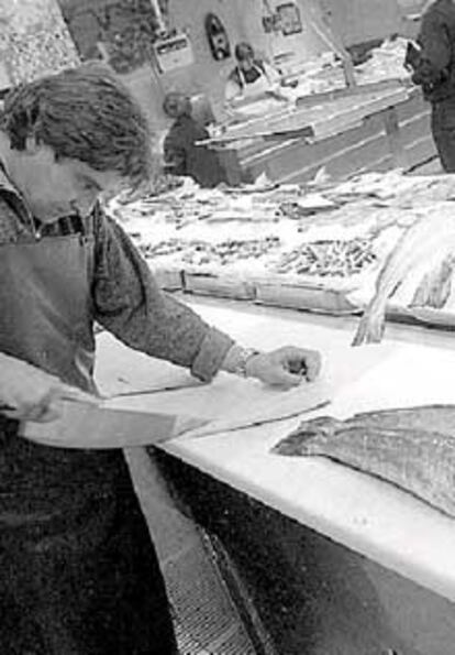 Un pescadero corta una merluza en un mercado de San Sebastián.