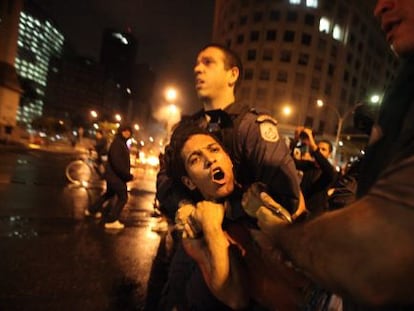 Police officers arrest a protestor on Tuesday night in Rio.