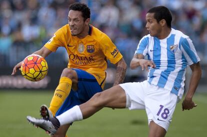 El defensa del Barcelona, Adriano, lucha por el balón contra Rosales, jugador del Málaga.