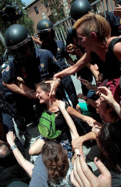 Los 'indignados' se resisten ante los agentes de la Policía, que tratan de despejar el Ayuntamiento para dejar paso a los coches oficiales.