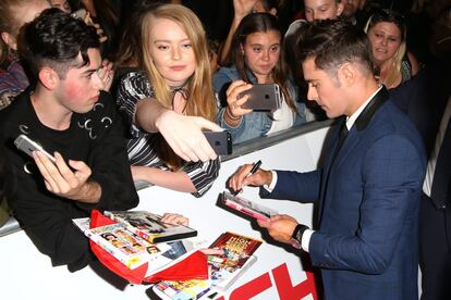 ¿Pero esto no era 'Los vigilantes de la playa'? Sí, pero (ay) a Zac Efron le perseguirá siempre 'High School Musical', por muchos abdominales que tenga ahora. Mirad los dvds que le hacen firmar los fans: todos de 'High School'. Y mirad como mira (sí, mucha redundancia) ese chico de la izquierda a Zac. Intensidad es poco...