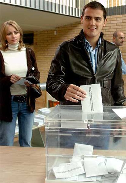 El candidato de Ciutadans-Partido de la Ciudadanía a la presidencia de la Generalitat, Albert Rivera Díaz, acompañado de su mujer, Mariona, ha depositado su papeleta en el colegio público Els Pinetons de la Garriga. La plataforma fue creada el pasado mes de julio y concurre por primera vez a los comicios catalanes, liderada por el joven abogado Rivera (Granollers, 1979). La imagen de Rivera llegó con más fuerza a la ciudadanía después de la presentación del cartel electoral de Ciutadans, en el que el candidato aparecía desnudo, tapándose los genitales con ambas manos y con el lema "Sólo nos importan las personas".