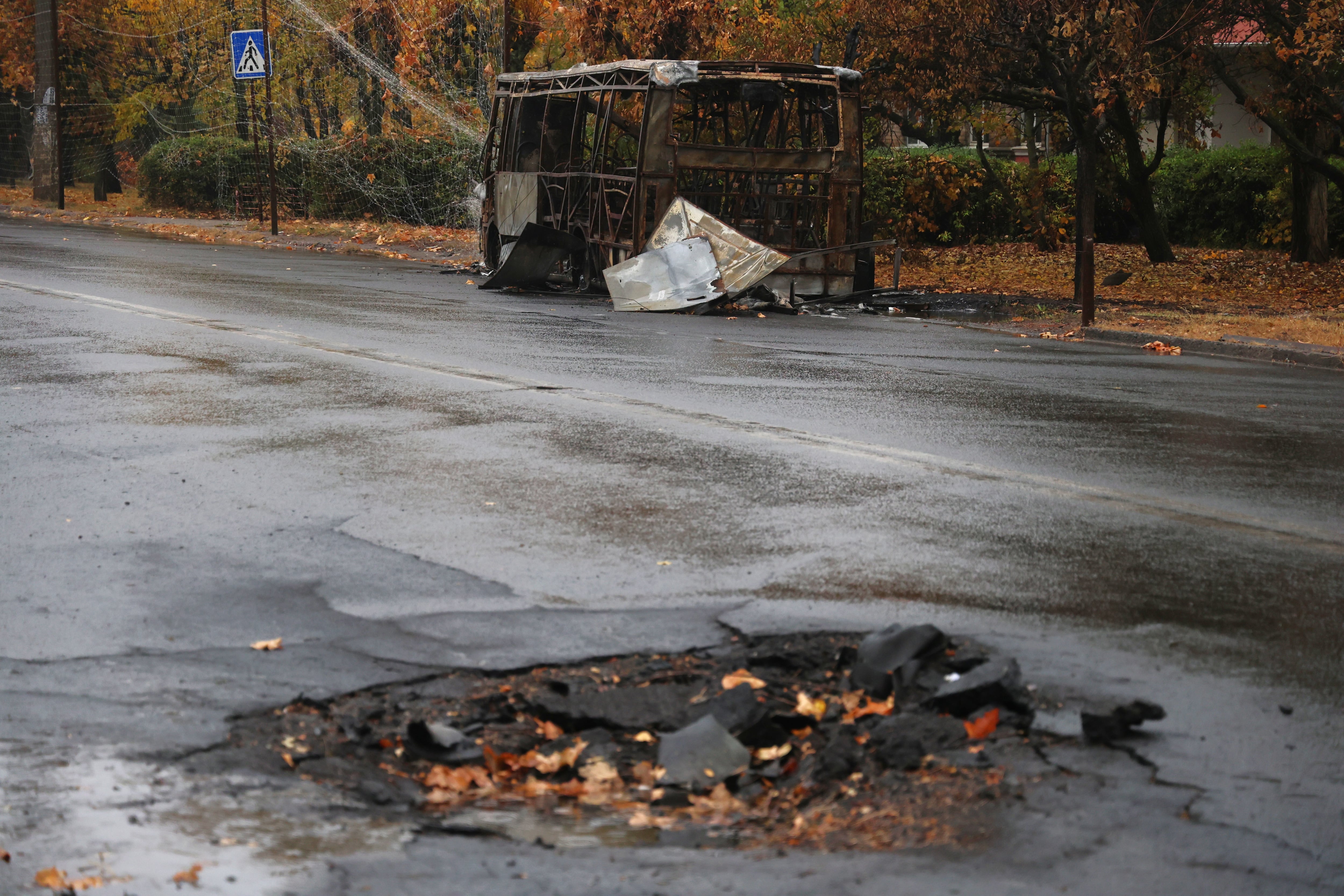 Impacto que dejó el 8 de octubre una bomba rusa que asesinó a 30 personas que iban en dos autobuses en Kramatorsk, uno de ellos aparece al fondo.