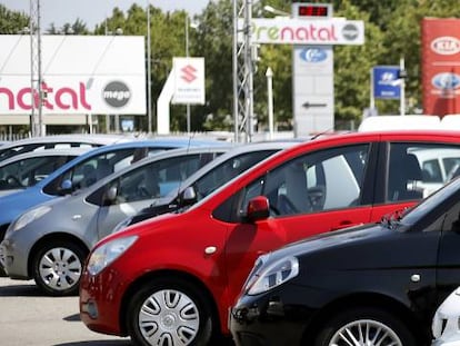 Una mujer examina vehículos en un espacio de compraventa.