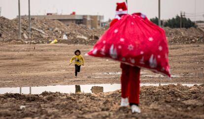 Un niño corre hacia Papá Noel, en un barrio pobre cerca del centro de la ciudad de Basora, en el sur de Irak, el 24 de diciembre.