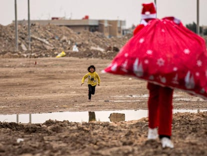 Un niño corre hacia Papá Noel, en un barrio pobre cerca del centro de la ciudad de Basora, en el sur de Irak, el 24 de diciembre.