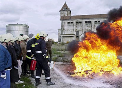 Un grupo de inspectores de armas de la ONU observa cómo dos soldados austriacos extinguen un fuego