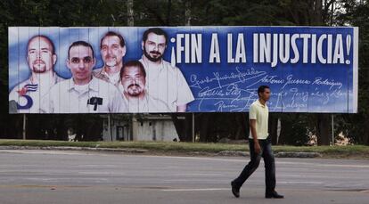 Homem caminha diante de imagem do chamado grupo dos "Cinco Heróis" em Havana (Cuba). O Governo dos EUA libertou os três remanescentes do grupo, os espiões cubanos Gerardo Hernández, Ramón Labañino e Antonio Guerrero em troca de um agente de inteligência americano preso há quase 20 anos em Cuba, e de Alan Gross, americano preso em Havana desde 2009.