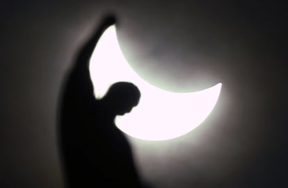 Eclipse solar visto entre las estatuas de la catedral de Milán (Italia).
