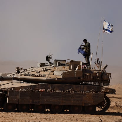 An Israeli soldier stands on a tank on the Israeli side of the border with Gaza, Israel August 20, 2025. REUTERS/Amir Cohen