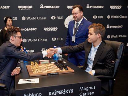 Caruana y Carlsen se saludan al inicio de la 1ª partida del Mundial ante los árbitros, Stéphane Escafre y Nana Alexandria