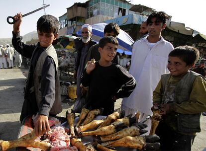 Un niño trocea huesos en un puesto del mercado de Kabul.