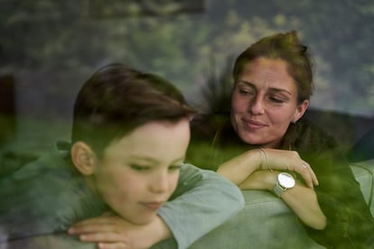 Una mujer y su hijo, apoyados en un sofá.
