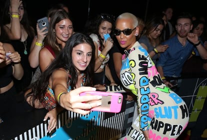 Amber Rose posa para uma 'selfie' com uma das pessoas presentes na festa.