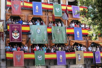 Los vecinos de Toledo ven la procesión desde los balcones que engalanan con banderas para la festividad del Corpus Christi.