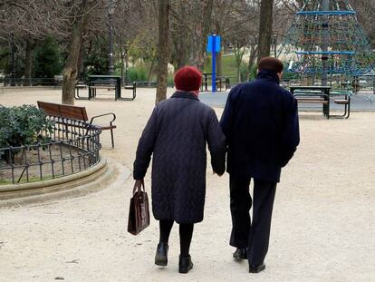 Dos personas caminando por un parque de Madrid.