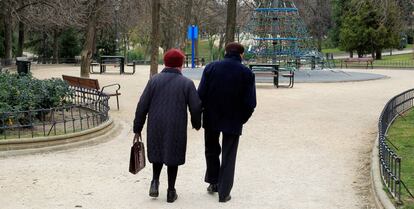 Dos personas caminando por un parque de Madrid.