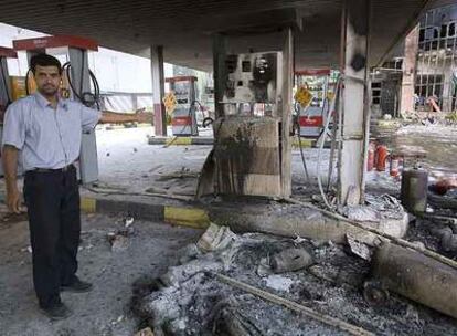Un hombre muestra los daños causados durante las protestas contra el racionamiento de combustible en una gasolinera de Teherán.