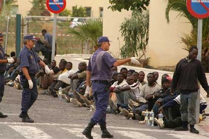 Sólo cien de los más de 500 inmigrantes que intentaron la pasada madrugada saltar la valla que separa Melilla de Marruecos lograron alcanzar territorio español. En la imagen, permanecen retenidos por las fuerzas de seguridad en la ciudad autónoma, a la espera de su expulsión.