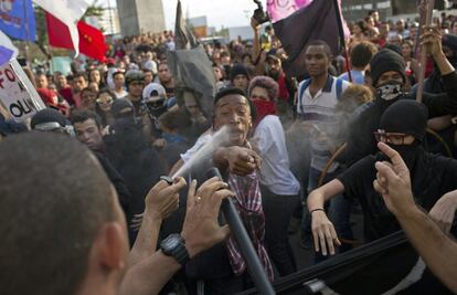 Un oficial de policía rocía con espray de pimienta a un grupo de manifestantes en Niteroi (Brasil) el 2 de agosto.