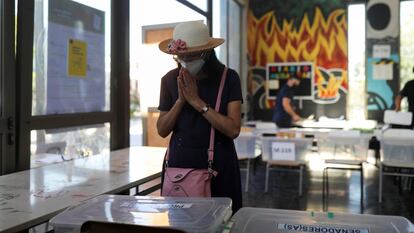 Una mujer reza a la momento de emitir su voto en una casilla de Santiago de Chile.