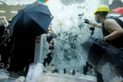 Manifestantes rompiendo las ventanas del Parlamento de Hong Kong.