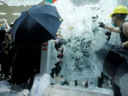 Manifestantes rompiendo las ventanas del Parlamento de Hong Kong.