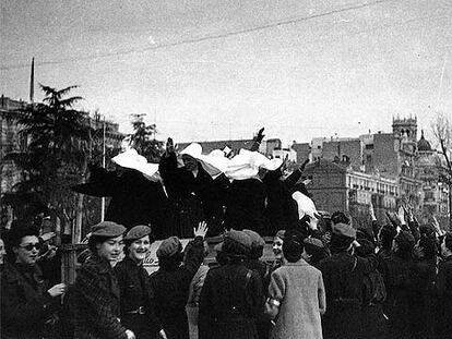 Un grupo de monjas saluda brazo en alto desde un camión a la gente congregada en Madrid, recién terminada la Guerra Civil.