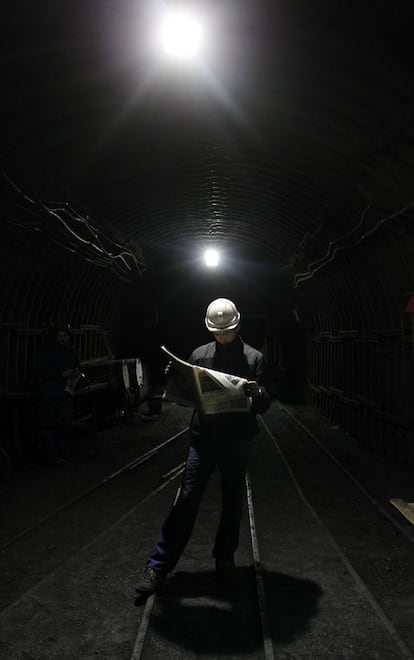 Uno de los mineros que participa en el encierro, lee un periódico en una de las galerías de la mina de Velilla del Rio, Palencia.
