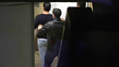 Un policía detenido entrando a los calabozos en Marbella.