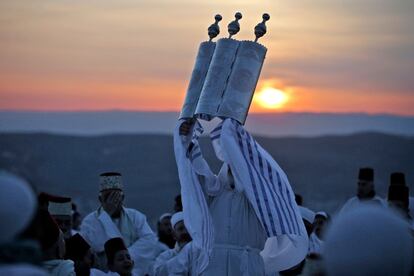 Un sacerdote samaritano levanta el rollo de la Torá mientras los fieles se reúnen para rezar durante una ceremonia de pascua en la cima del Monte Gerizim, al norte de Cisjordania.