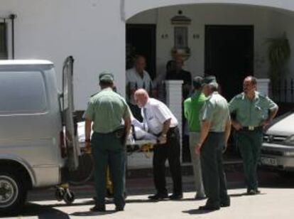 Miembros de los servicios funerarios sacan el féretro con el cuerpo sin vida del párroco de la localidad de Villafranca de Córdoba, que apareció hoy en su domicilio del municipio con evidentes signos de violencia.