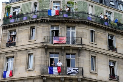 Varios residentes esperan desde sus balcones el comienzo de la ceremonia de apertura de los Juegos Olímpicos junto al río Sena. 
