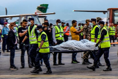 Las fuerzas de seguridad trasladan el cadáver de una de las víctimas del accidente, este lunes en el aeropuerto internacional de Katmandú.