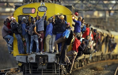 El pasado 18 de septiembre pasajeros de un tren en Soweto (Sudáfrica) se sujetan al exterior de la locomotora y de los vagones.
