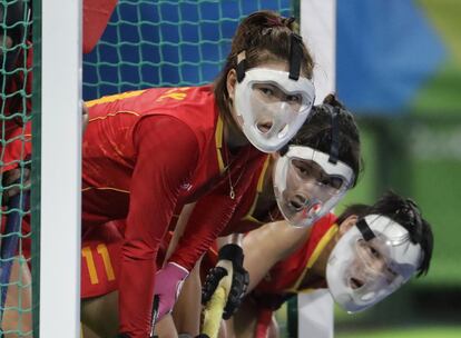 Las jugadores chinas de hockey hierba utilizan mascarillas protectoras mientras esperan un sque de esquina del equipo de los Países Bajos.