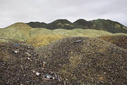 In this Tuesday, Jan. 26, 2016 photo, broken glass bottles are piled up later to be recycled at the Phoenicia Glass Works Ltd. factory in the southern Israeli town of Yeruham. Tiny shards, millions of them, are piled into rolling hills of green and brown. They are 50 feet high and span the length of a few soccer fields. This is the junkyard at Israelx92s only glass container factory, where broken glass awaits a new life. (AP Photo/Oded Balilty)