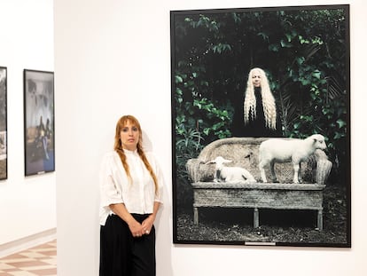 La fotógrafa Estela de Castro, junto a la uno de los retratos que presenta en La Térmica de Málaga.