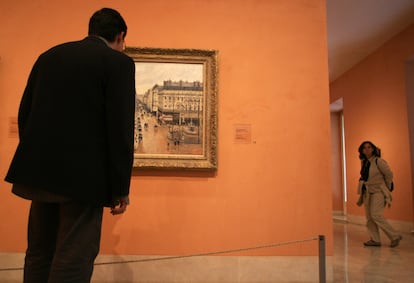 Un visitante observa el cuadro 'Rue Saint-Honoré por la tarde. Efecto de lluvia', de Camille Pisarro, en el museo Thyssen-Bornesmisza de Madrid.