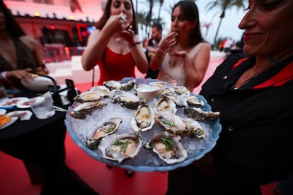 Invitadas a la fiesta de presentación del hotel de cinco estrellas The Unexpected Ushuaïa degustan ostras de su Oyster & Caviar Bar, a principios de junio.