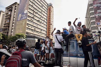 Jóvenes gritan arengas desde los techos de automóviles.