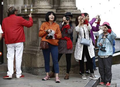 Un grupo de turistas toman fotografías en la Plaza del Ayuntamiento de Pamplona.