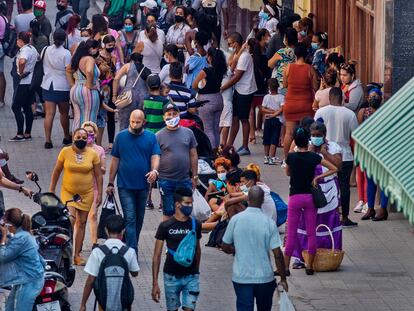 Varias personas caminan para entrar a tiendas en la calle Obispo, el viernes 28 de enero del 2022, en La Habana, Cuba.