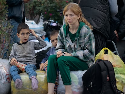 Una mujer y dos niños sentados sobre sus pertenencias tras huir de Nagorno Karabaj a la ciudad armenia de Goris, el 28 de septiembre.