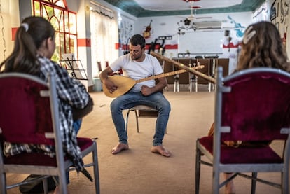 Fahad impartiendo clase de música a niños y niñas retornadas en la escuela que junto a Gani Mirzo instalaron en la ciudad de Xana Sore al pie de las montañas de Sinjar.